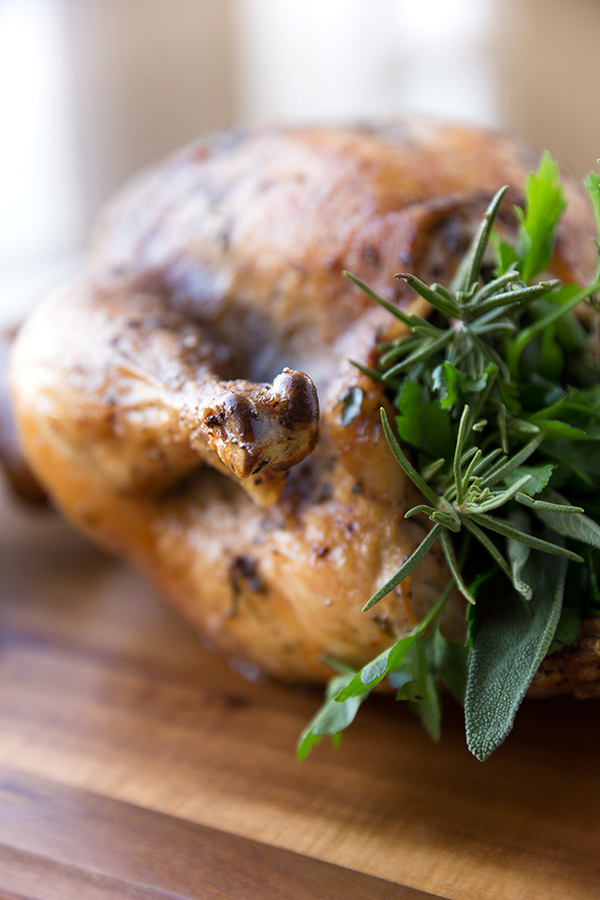 Closeup on fresh herbs stuffed in Herb Roasted Chicken | thecozyapron.com