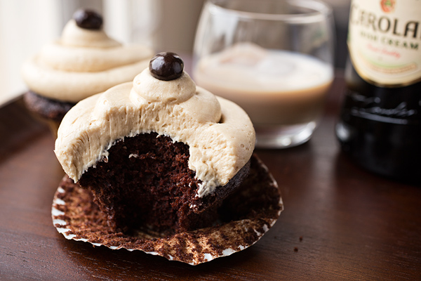 Irish Cream Coffee Cupcake with a bite out of it and a glass of Irish Cream | thecozyapron.com