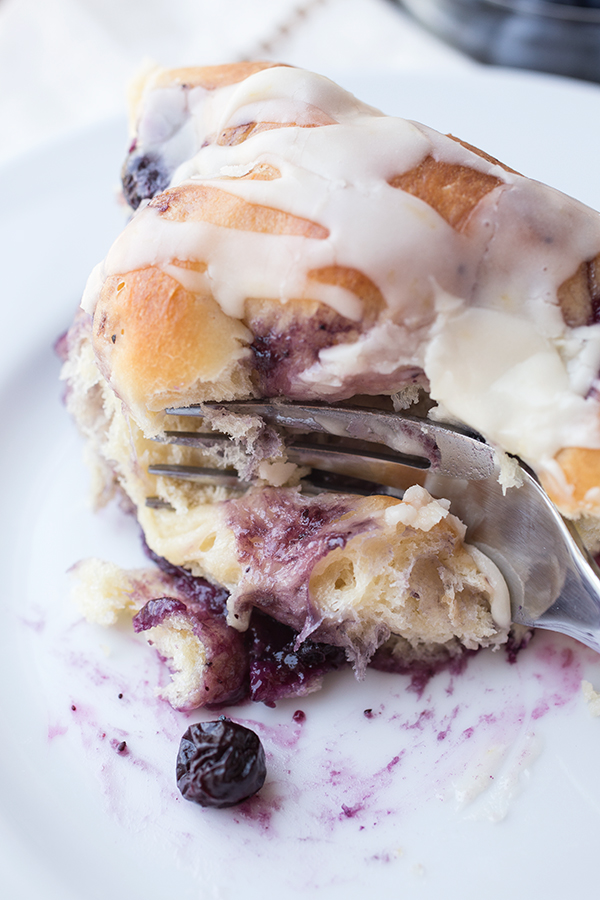 A forkful of a fresh-baked Blueberry Roll on a plate | thecozyapron.com