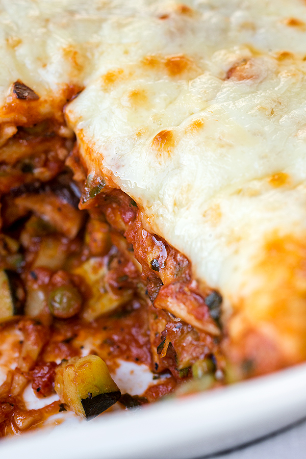 Closeup of freshly baked Lasagna Primavera showing layers of colorful vegetables, pasta, and melted cheese | thecozyapron.com