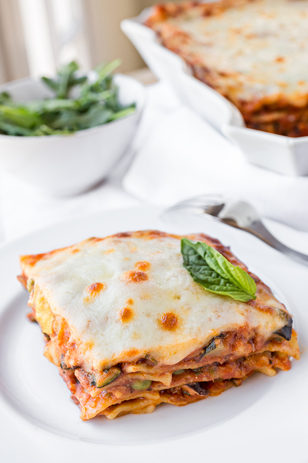 A serving of lasagna primavera showing the layers of vegetables, pasta, and melted cheese | thecozyapron.com