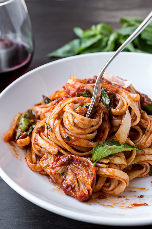 Linguine Pasta with Sausage and Artichoke swirled around a fork | thecozyapron.com