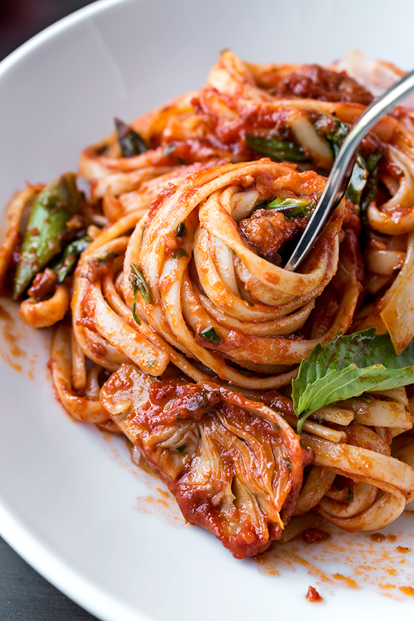Closeup on Linguine Pasta with Sausage and Artichoke swirled around a fork | thecozyapron.com