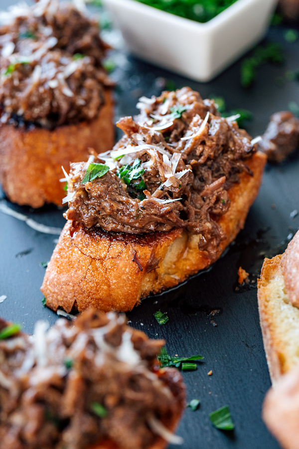 Closeup on Red Wine Braised Short Ribs on garlic crostini | thecozyapron.com