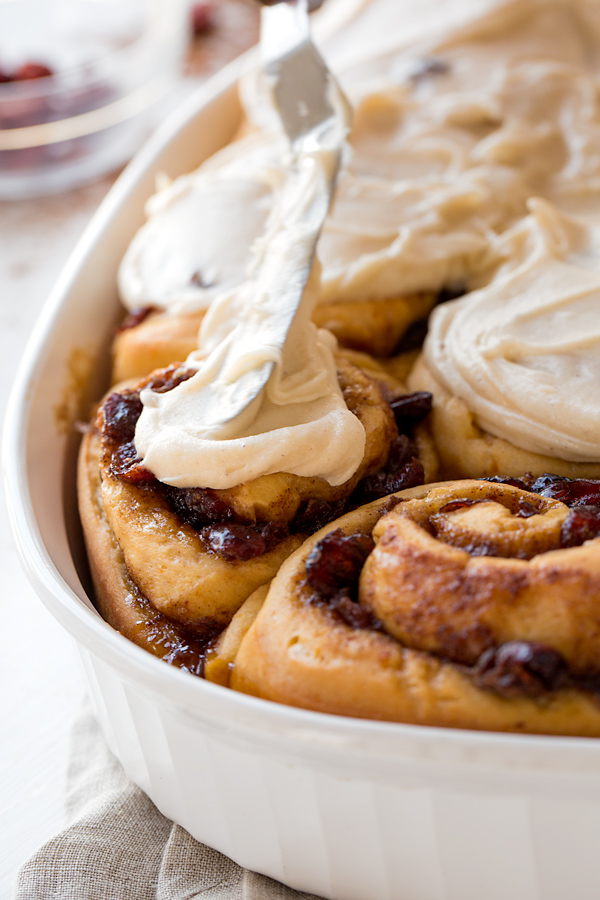 Spreading Orange Cinnamon Rolls with Rich Frosting | thecozyapron.com
