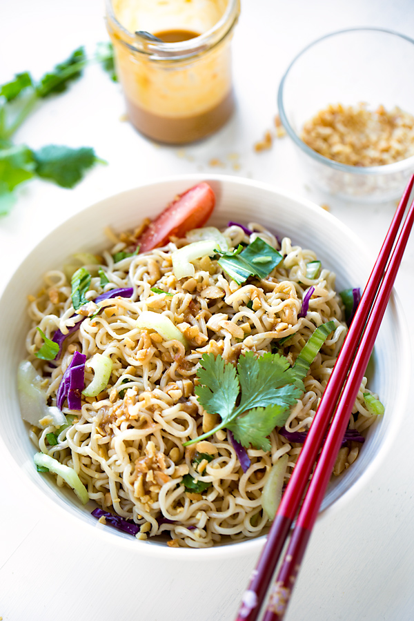 A bowl of Ramen Noodle Salad with chopsticks and some peanut dressing on the side | thecozyapron.com
