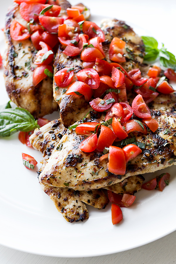 Close-up on Grilled Chicken Breasts with Tomato-Basil Salsa on a white plate | thecozyapron.com
