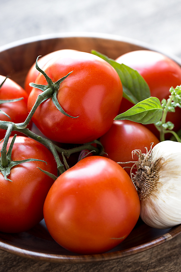 A beautiful bowl of fresh tomatoes, garlic, and basil for Caprese Toasts | thecozyapron.com