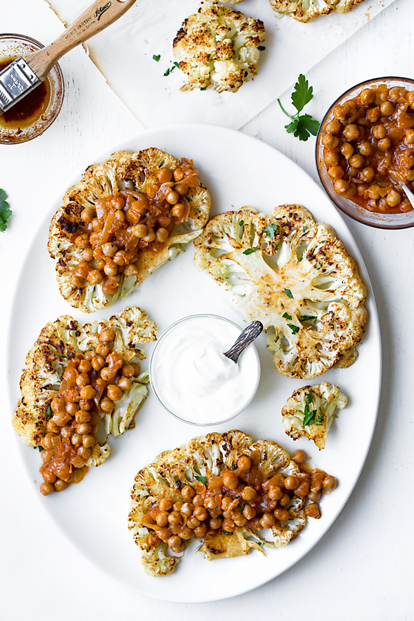 A serving platter of Cauliflower Steaks with Harissa Chickpeas | thecozyapron.com
