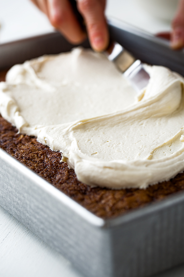 Chinese Five Spice Cake being frosted with Ginger Cream Cheese Frosting | thecozyapron.com