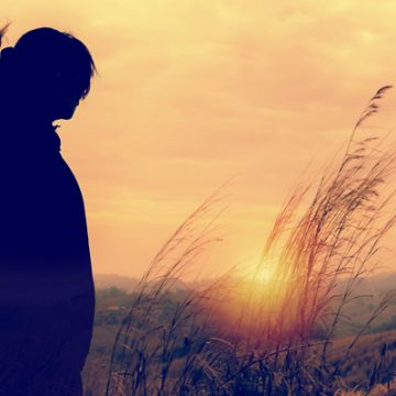 Woman in field watching the sun set | thecozyapron.com