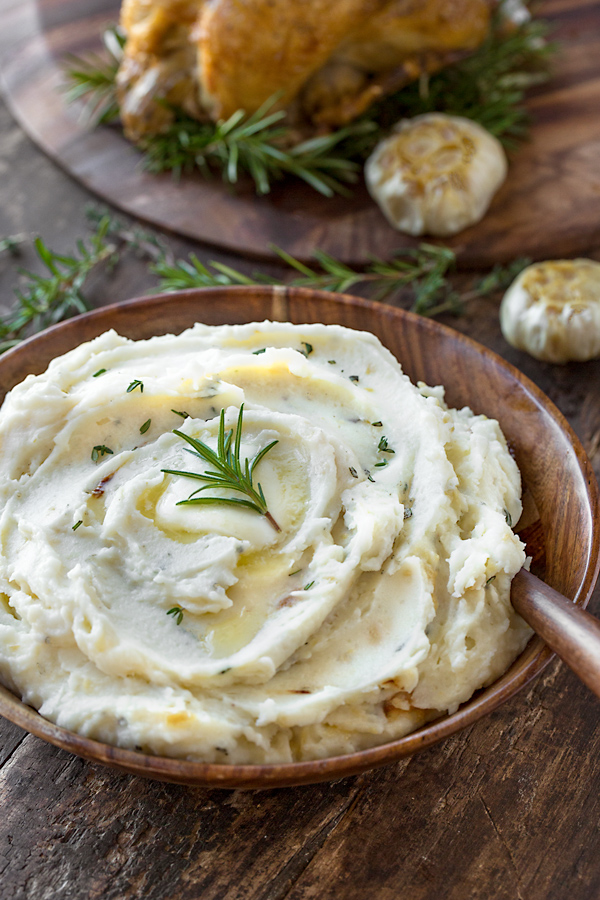A beautiful wooden serving bowl of Roasted Garlic Mashed Potatoes | thecozyapron.com