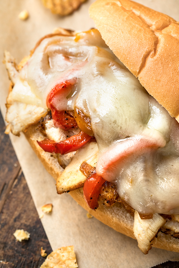 Closeup on a hot Chicken Cheesesteak with a few chips on the side | thecozyapron.com