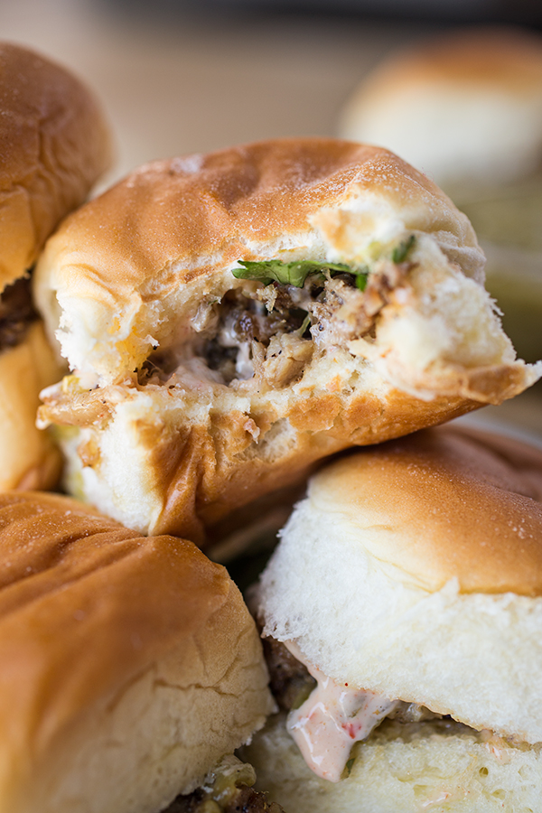 Stack of Pulled Pork Sliders with a bite taken out of the one on top  | thecozyapron.com