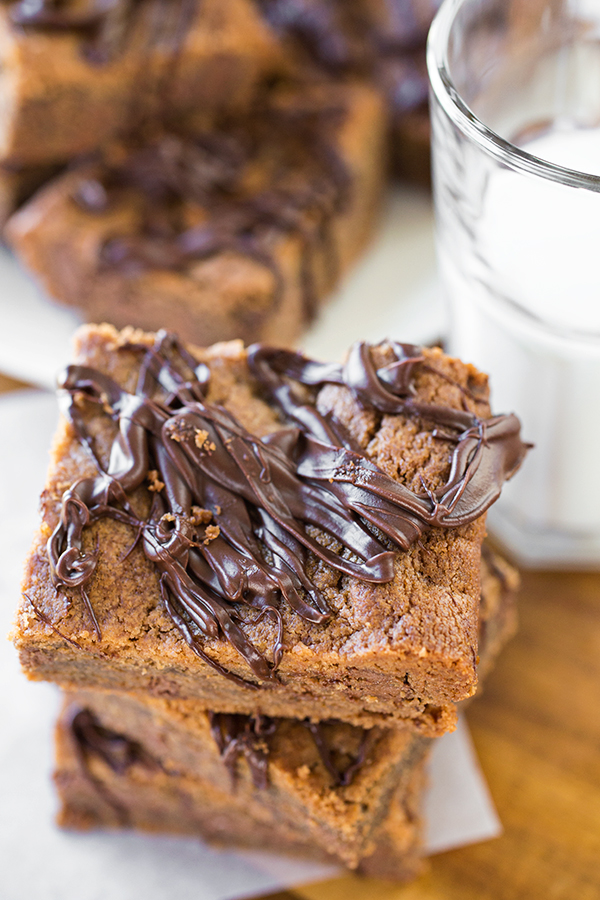 Stack of Chocolate Peanut Butter Bars with a glass of milk | thecozyapron.com